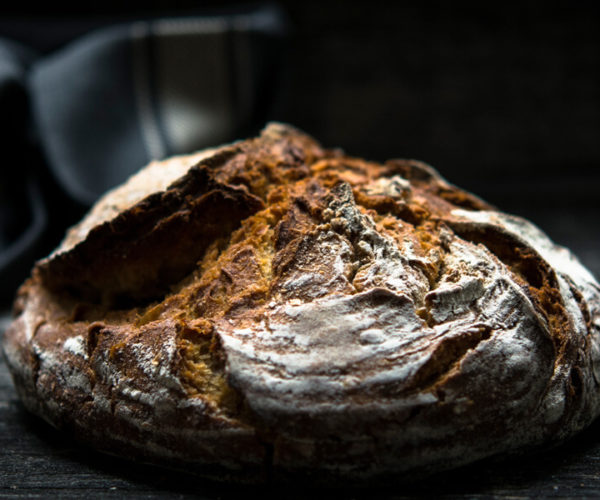 pain de campagne sur fond sombre servie à la table de trois à Bordeaux